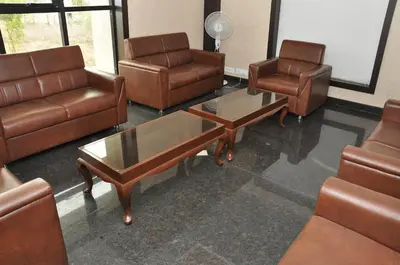 a waiting room with leather chairs and a coffee table at Hotel Royal Chambers in Coimbatore