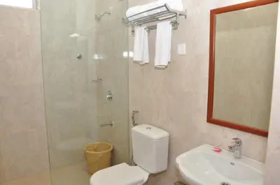 a bathroom with a shower and a toilet and a sink at Hotel Royal Chambers in Coimbatore