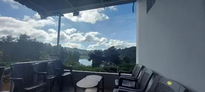 a balcony with chairs and a view of a lake at Sky High Villa - Premium Cottages in Ooty