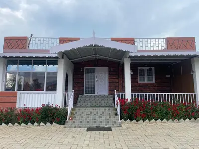 a brick house with a white door and stairs at Sky High Villa - Premium Cottages in Ooty