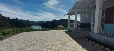 a house with a brick driveway with a view of a lake at Sky High Villa - Premium Cottages in Ooty