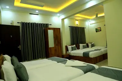 a hotel room with two beds and a mirror at Homey Residency vythiri in Padinjarathara