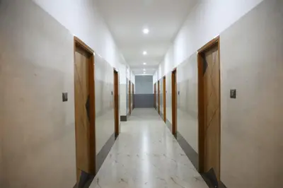 a corridor of a hallway with wooden doors and a row of halls at Viruksham Residency in Palani