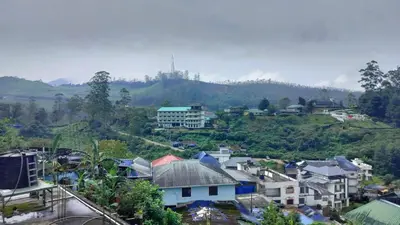 a view of a town with houses and a mountain at Achus Holidays in Munnar