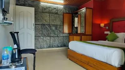 a bedroom with a bed and a red wall at Achus Holidays in Munnar