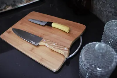 a cutting board with a knife on top of it at Cozy 3 BHK PoolVilla near Nagerhole National park. in Wayanad