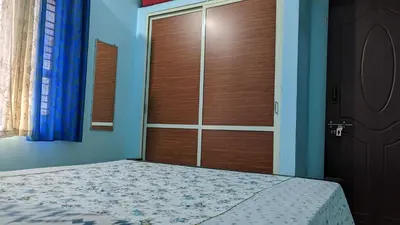 a bedroom with a wooden door and a bed at Delight Homestays Coorg in Kushālnagar