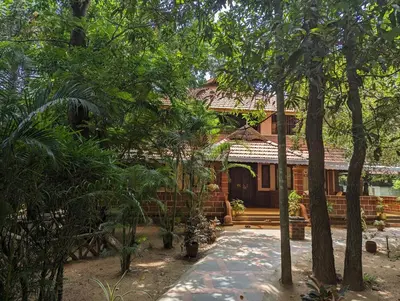a house in the middle of a garden with trees at Neelambari Ecotoursm in Trichūr