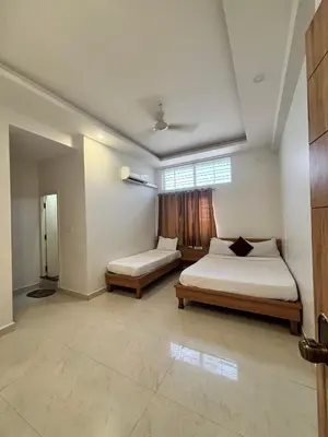 a bedroom with two beds and a window at Seema Palace Inn 1 km from Railwaystaion in Mysore