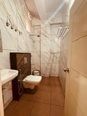 a bathroom with a toilet and a sink at Seema Palace Inn 1 km from Railwaystaion in Mysore