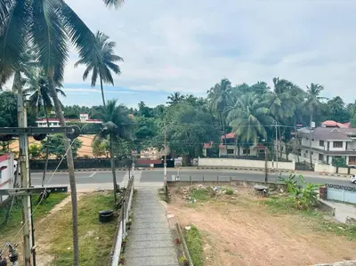 a street with palm trees on the side of a road at Soorya Madhavam Apartment Guruvayur - 200 m from temple walkable in Guruvāyūr