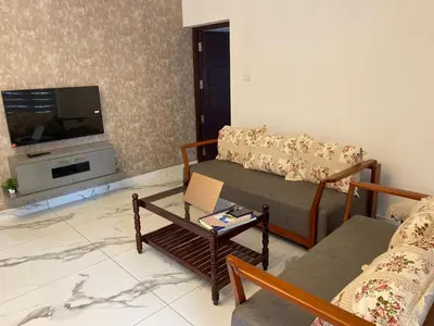 a living room with a couch and a tv at Elegant RiverView Villa in Cochin