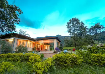 a house with a garden in front of it at Viriparai Tea Bungalow Munnar by VOYE HOMES - Surrounded by Tea Plantations in Munnar