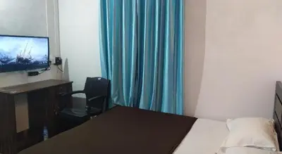 a bedroom with a bed and a desk and a television at River view cottage in Vythiri