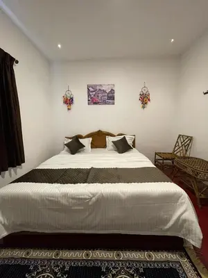 a bedroom with a large white bed in a room at Sandy Holiday Home 5 Bhk in Ooty