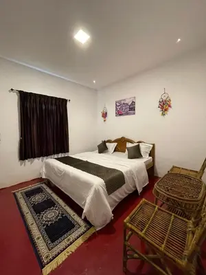 a bedroom with two beds and a chair at Sandy Holiday Home 5 Bhk in Ooty