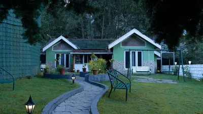 a green house with a bench in the yard at The Green Casa By Green leaves -Families Only in Ooty