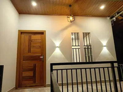 a hallway with a wooden door and a staircase at Paradise Single Room in Wayanad