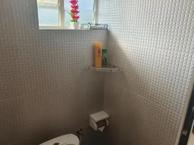 a bathroom with a toilet and a window at Sancta Maria Airport Hotel in Cochin