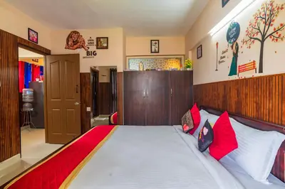 a bedroom with a large bed with red and white pillows at Sancta Maria Airport Hotel in Cochin