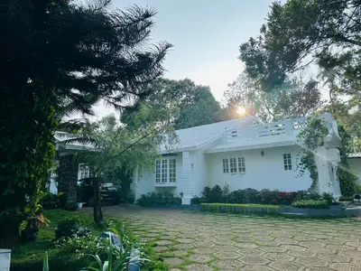 a white house with a driveway in front of it at The Mallika Holidays in Mananthavady