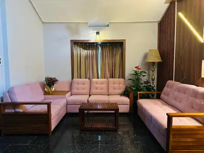 a living room with pink couches and a table at The Mallika Holidays in Mananthavady