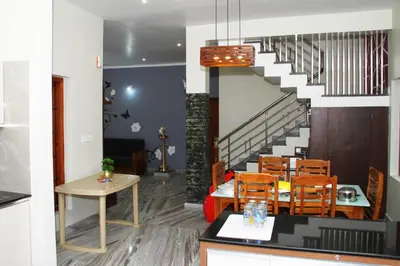 a dining room with a table and a staircase at Airy Homestay Ooty by Lexstays in Ooty