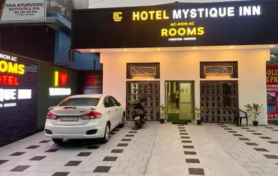 a white car parked in front of a hotel at Mystique Inn Wayanad-vythiri in Vythiri