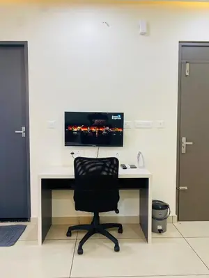 a black chair sitting at a desk with a monitor at RIVULET HOTEL APARTMENTS in Mukkam