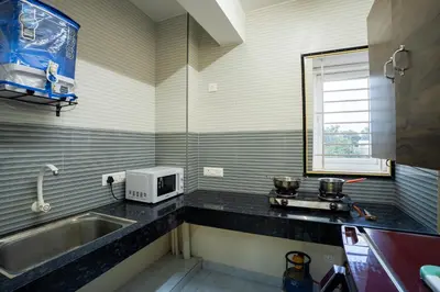 a kitchen with a sink and a microwave at Aafiya lakeview Apartments in Coimbatore