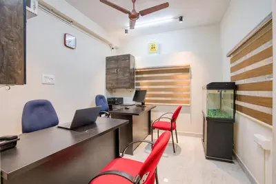 an office with a desk and chairs and a fish tank at Aafiya lakeview Apartments in Coimbatore