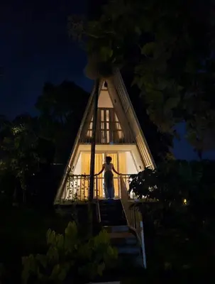 a person standing on the stairs of a house at The Mallika Holidays - A Cabin in Mananthavady