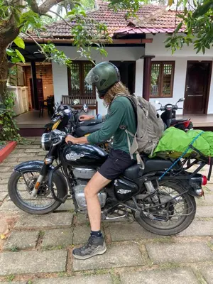 a man with a helmet sitting on a motorcycle at Dove cottage in Cherai Beach