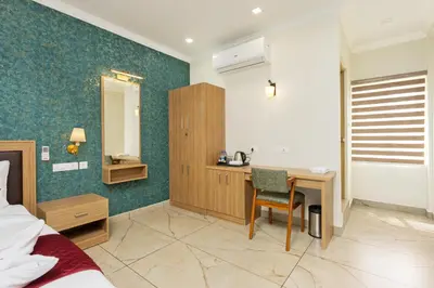 a hotel room with a desk and a bedroom at ESAA Airport Hotel in Cochin