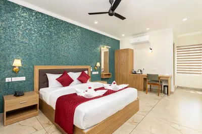 a bedroom with a large bed with red pillows at ESAA Airport Hotel in Cochin