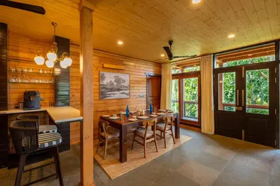 a dining room with a table and chairs at amã Stays and Trails The Malabar Villa Hibiscus, Kozhikode in Puthuppādi