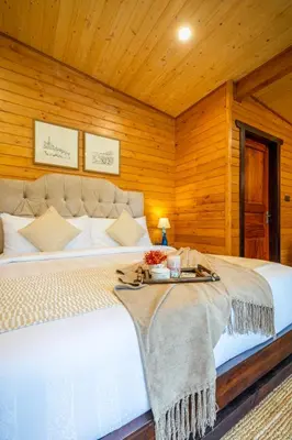 a bedroom with a white bed with a tray on it at amã Stays and Trails The Malabar Villa Hibiscus, Kozhikode in Puthuppādi