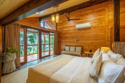 a bedroom with a large bed in a room with wooden walls at amã Stays and Trails The Malabar Villa Hibiscus, Kozhikode in Puthuppādi