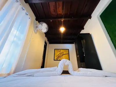 a bed with white sheets and a wooden ceiling at Paroommel Haven Wayanad in Kenichira