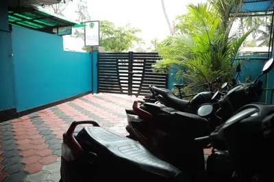 a row of motorcycles parked next to a blue wall at Sajeev Home Stay in Cherai Beach