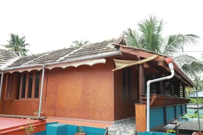 a small house with a palm tree on top of it at Sajeev Home Stay in Cherai Beach