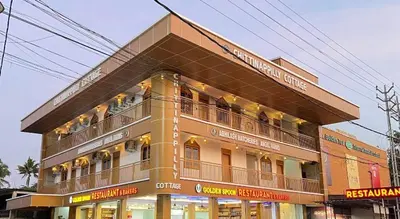 a building with people sitting on the balconies of it at Chittinappilly Cottage in Angamali