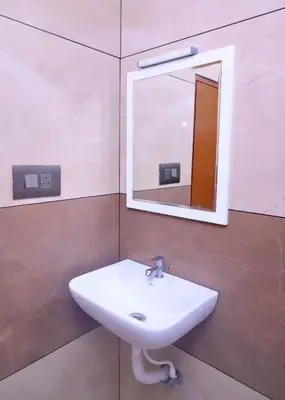 a bathroom with a sink and a mirror at Chittinappilly Cottage in Angamali