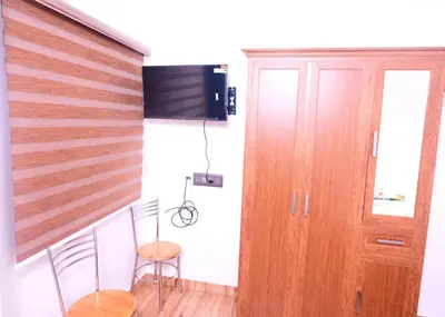 a room with two chairs and a staircase with a television at Chittinappilly Cottage in Angamali