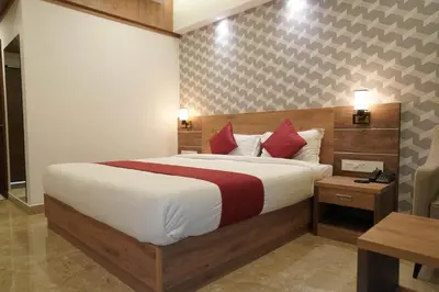 a bedroom with a large bed with red pillows at HOTEL VKJ INN Aluva in Alwaye