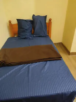 a blue bed with blue sheets and blue pillows at 4 Bedroom Jungle Villa in Panamaram