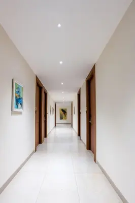 an empty corridor of an office building with white walls and a long hallway at HOTEL ACHYUT in Tiruppūr