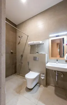 a bathroom with a toilet and a sink at HOTEL ACHYUT in Tiruppūr
