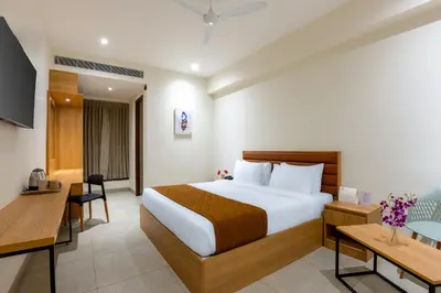 a hotel room with a bed and a desk at HOTEL ACHYUT in Tiruppūr