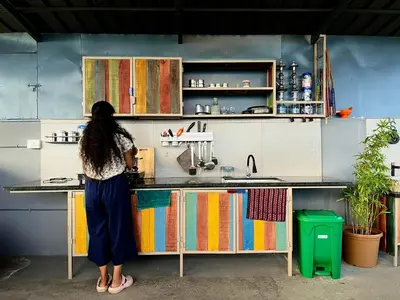 a woman is standing at a kitchen counter at Green Horizon, Luxury & Nature at Kothamangalam in Kotamangalam